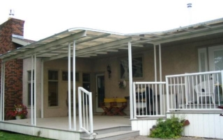 A white and transparent patio cover covering a deck with varying lengths