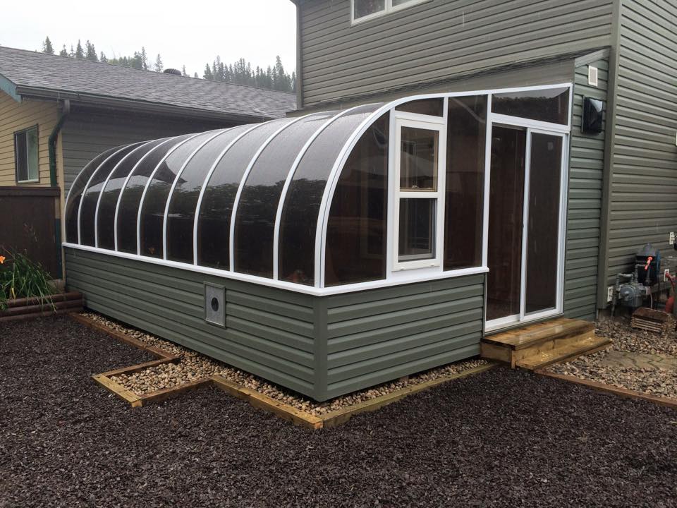 Exterior view of a curved eave sunroom with siding to match the house
