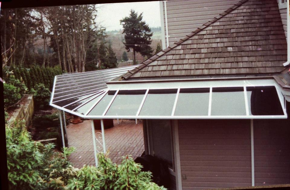 A straight end patio cover with a white frame that extends around a building
