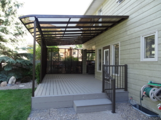 A curved end patio cover with a dark frame and transparent windows
