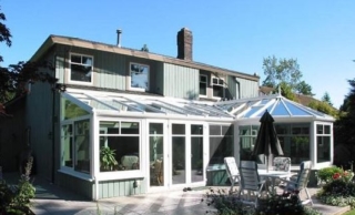 Exterior view of a white combined-style conservatory attached to a house