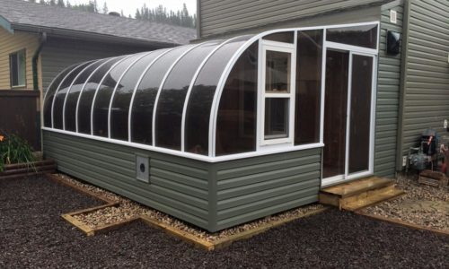Exterior view of a curved eave sunroom with siding to match the house