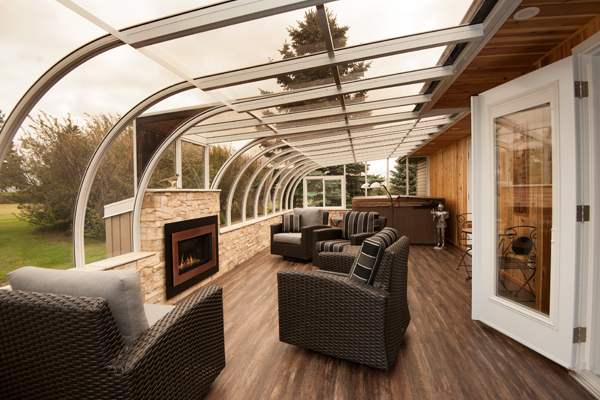 A white curved eave sunroom with furniture and fireplace